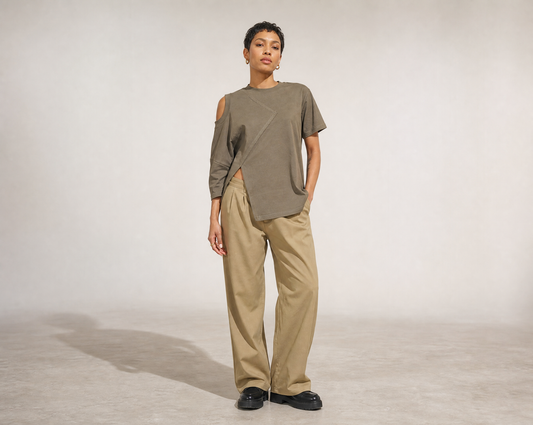 Person wearing a Mesan green oversized shirt and beige pants on a plain background